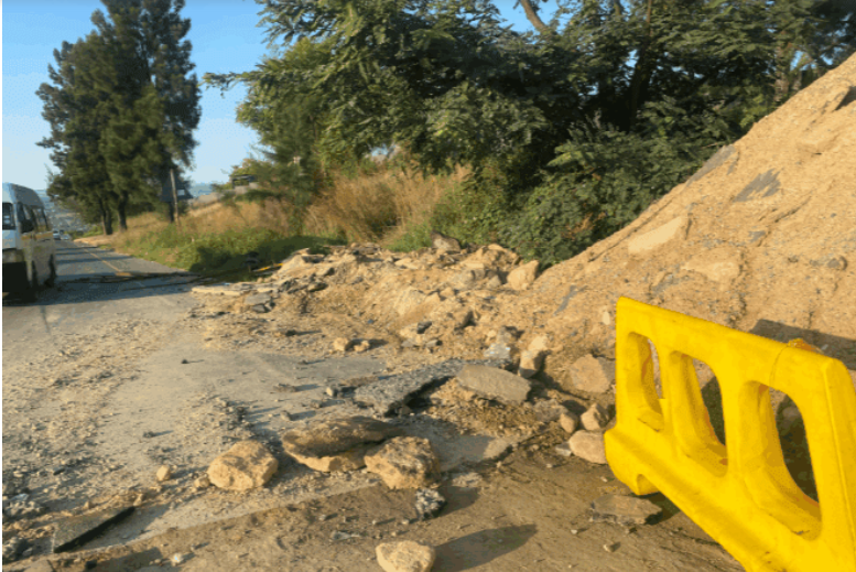 Construction materials and barriers remain at the unfinished R55 maintenance site, with no workers present. 
