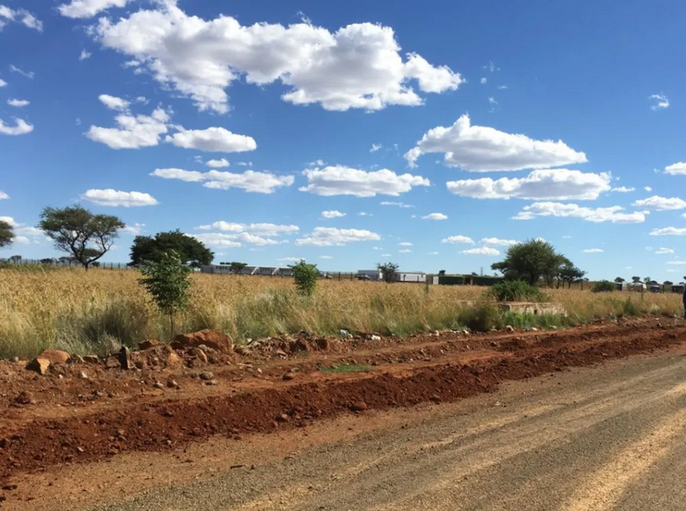The gravel road leading to the primary school. Next to the road, a fence is being erected on the terrain where the planned adjacent high school will be built.