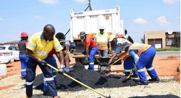 MMC for Roads and Transport, Clr Andile Mngwevu, with officials as they level the hot asphalt.