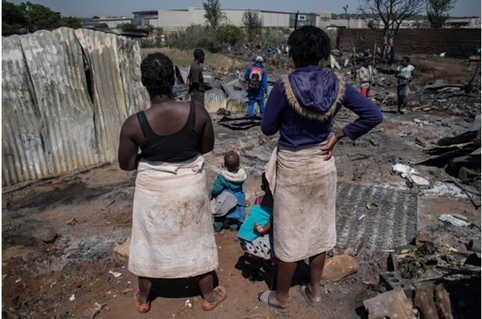 Residents among the burnt down shacks of the Plastic View 2 informal settlement near the Pretoria East Cemetery, 8 October 2018.
