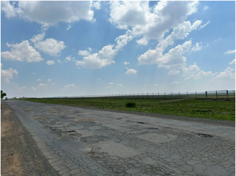 Road users are swerving to avoid craters in the road, and a major traffic incident or significant vehicle damage is imminent.