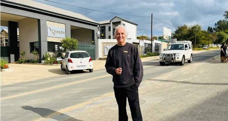 Ward 94 councillor David Foley highlights a section of road that still lacks its final tar surface after a previous water burst.
