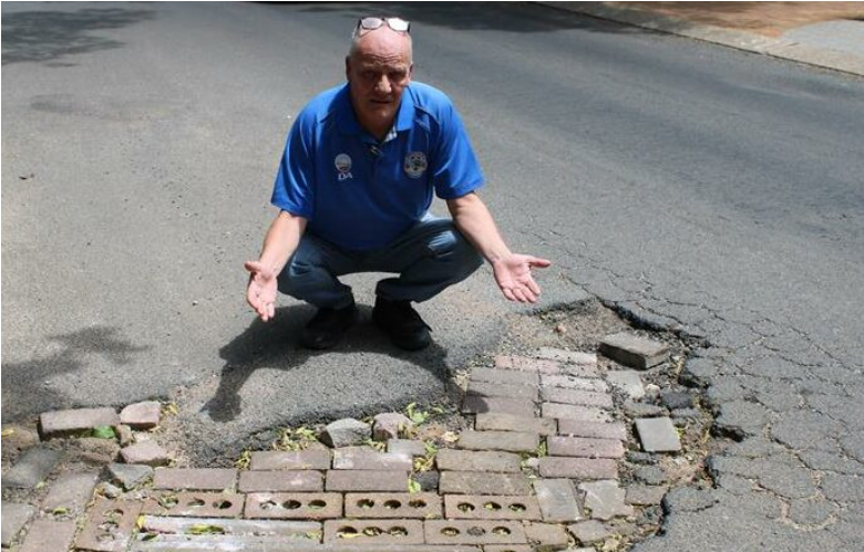  Ward 17 Clr Simon Lapping at a large pothole in Croyden. 