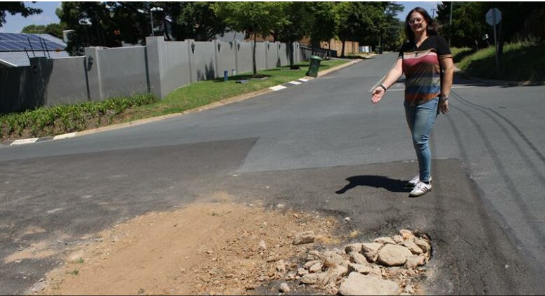Parkmore Community Association manager and Ward 90 committee member Lori Klein next to the sinkhole filled with soil at the corner of 5th Street and Victoria Avenue.