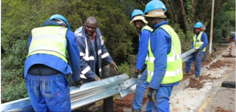  Contractors install new guardrails along the side of the road. 