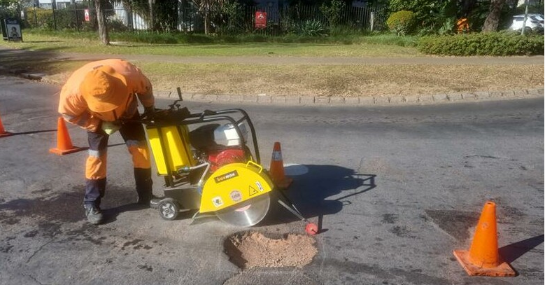 Image: Supplied. A volunteer repairs a pothole at an intersection.