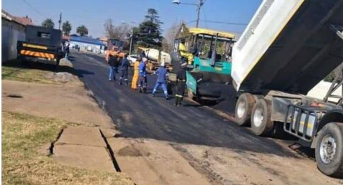  Construction workers resurfacing the road.