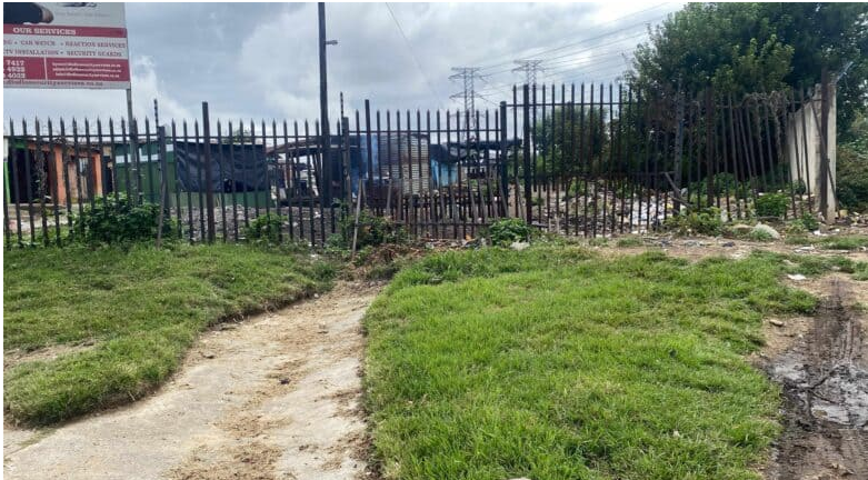 The palisade fence separating Mayibuye from Mastiff Road inside the Midrand Industrial Park. 