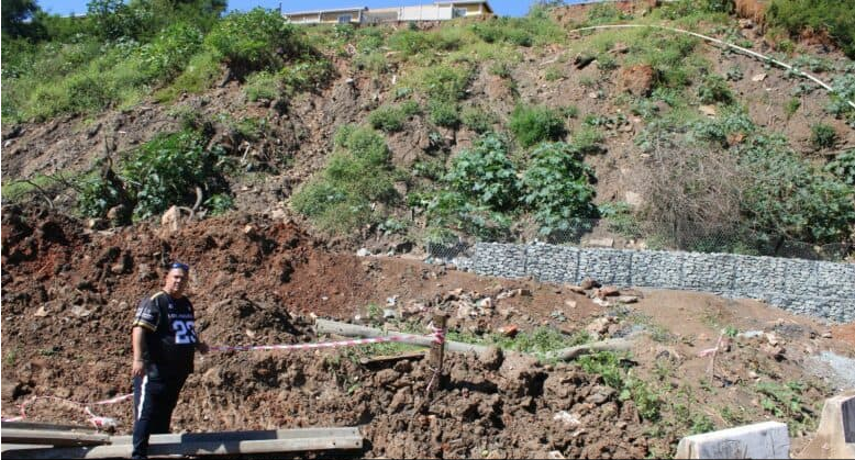 Ward councillor Andrew Akkers surveys the damage of the embankment collapse which has led to the closure of a section of Prince Mhlangana Road.