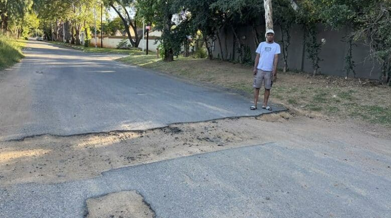  Lungelo Mashazi stands next to one of the biggest potholes on Nola Avenue in Buccleuch. 