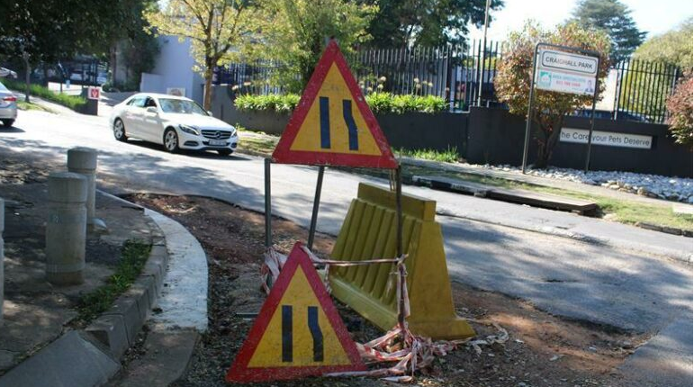  Road signs and a yellow plastic barricade are placed on Clarens and Buckingham avenues in Craighall Park.