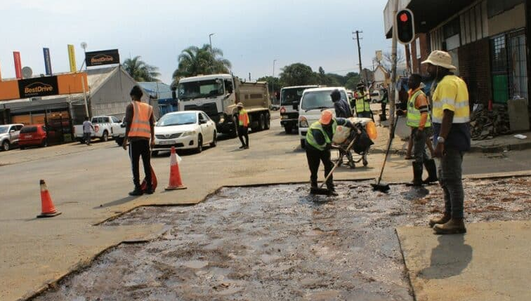  Municipal workers patch the road at Church Street. 
