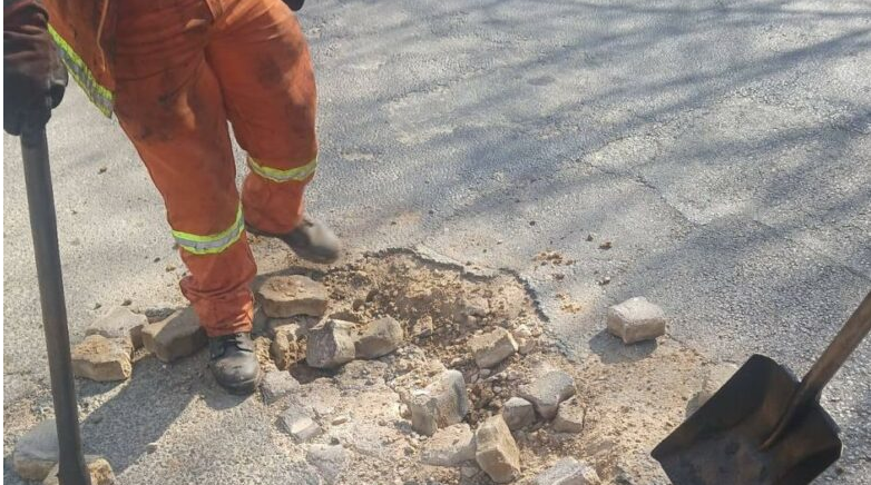  JRA employees remove concrete that residents previously used to fill dangerous potholes along Cedar Avenue West.