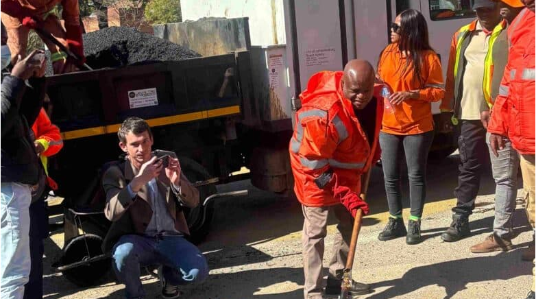  Executive Mayor Sello Dada Morero helps in fixing a pothole. 